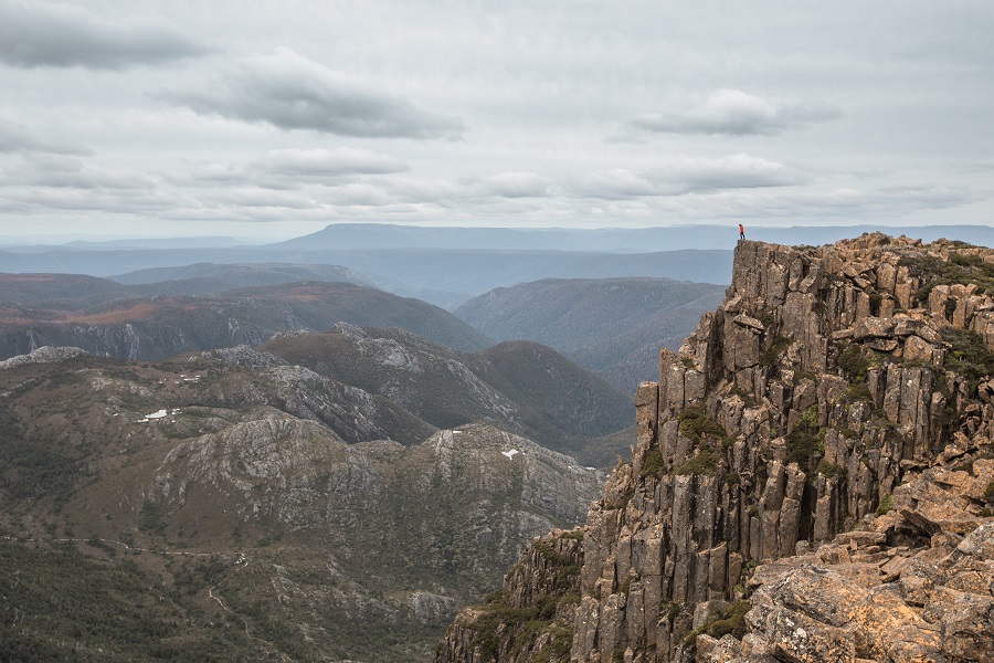 Standing on the edge of a cliff near the summit of Cradle Mountain