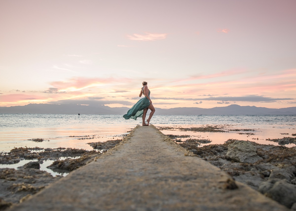 Woman in flowy dress at scenic sunset in Moalboal, Cebu